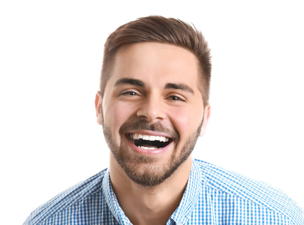 Knappe glimlachend jonge man op witte achtergrond - Foto, afbeelding