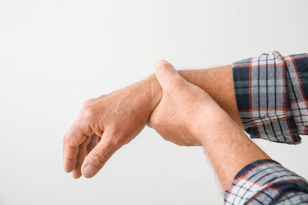 Älterer Mann mit Parkinson-Syndrom auf grauem Hintergrund - Foto, Bild