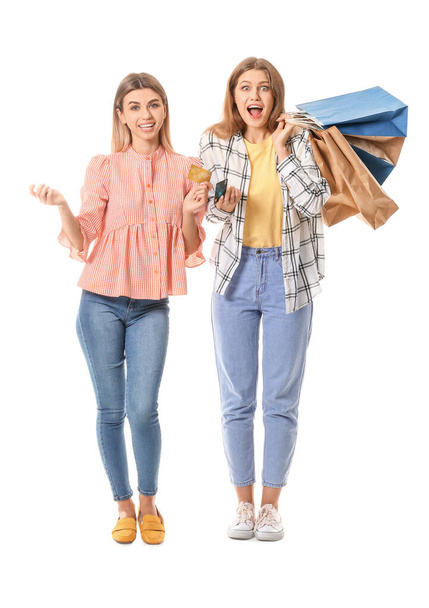 Young women with shopping bags and credit cards on white background - Photo, Image