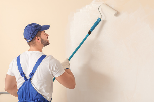 Male painter doing repair in room - Foto, afbeelding