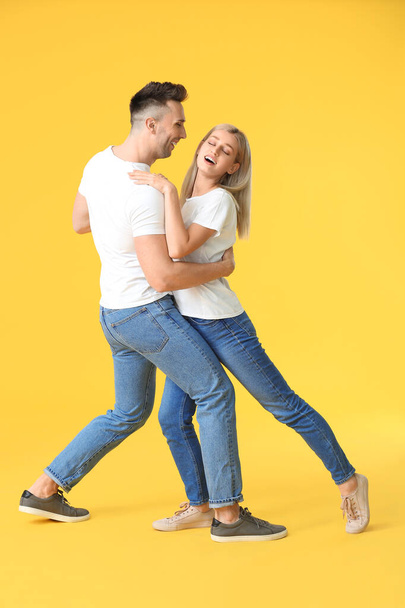 Happy dancing young couple on color background - Zdjęcie, obraz