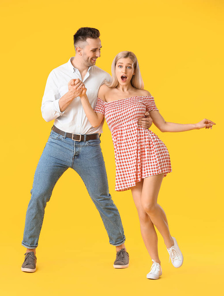 Ευτυχισμένο χορευτικό νεαρό ζευγάρι με φόντο το χρώμα - Φωτογραφία, εικόνα