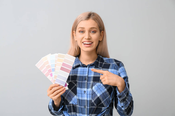 Молодая женщина с цветными образцами на сером фоне
 - Фото, изображение