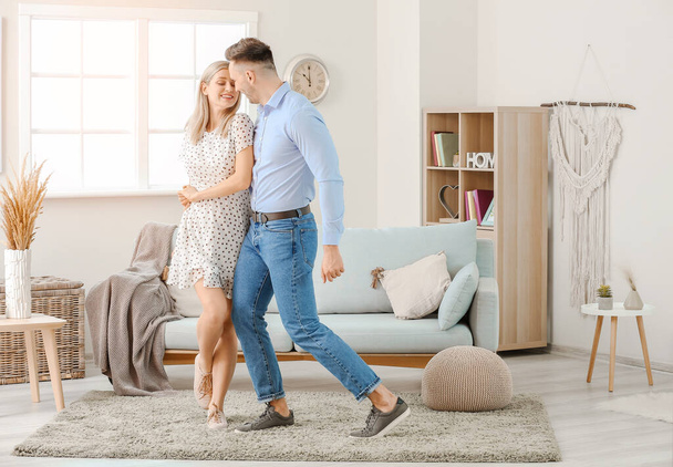 Happy dancing young couple at home - Foto, Imagen