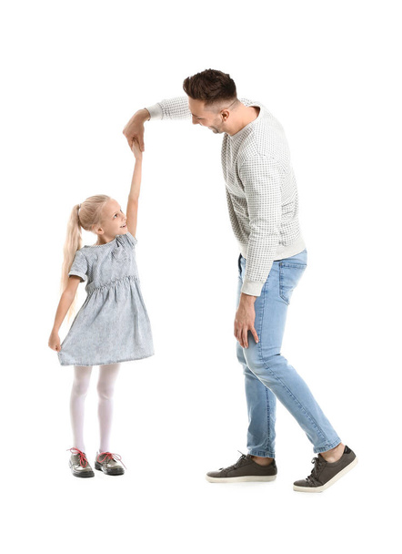 Man and his little daughter dancing against white background - Foto, imagen