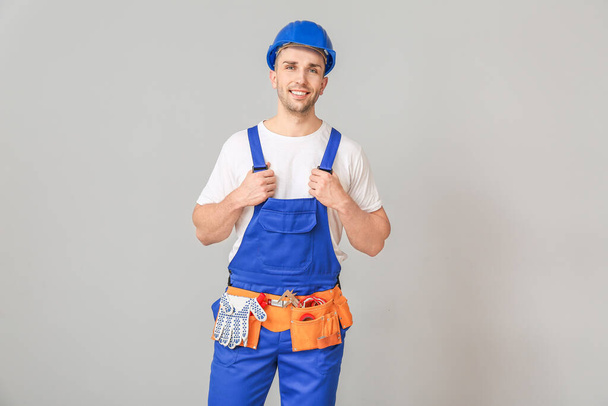 Handsome male worker on grey background - Photo, Image