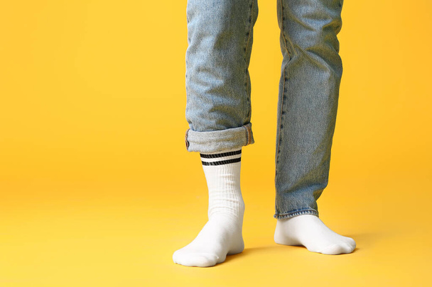 Male legs in socks and jeans on color background - Foto, Bild