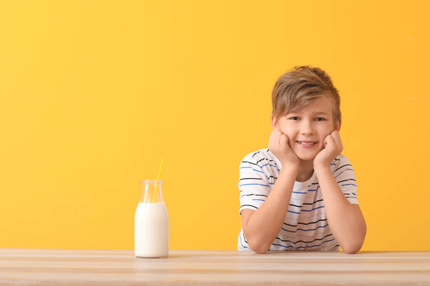 Little boy with milk on color background - Фото, изображение