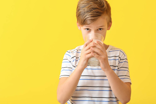 Kleiner Junge mit Milch auf farbigem Hintergrund - Foto, Bild