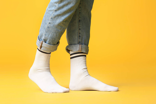 Pernas masculinas em meias e jeans no fundo de cor
 - Foto, Imagem