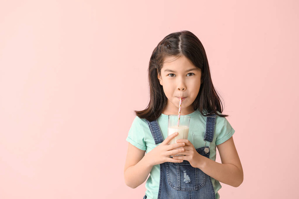 Cute Asian girl with milk on color background - Фото, изображение