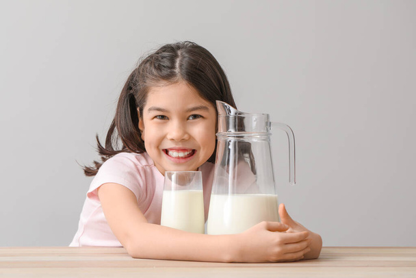 Menina asiática bonito com leite no fundo de luz
 - Foto, Imagem