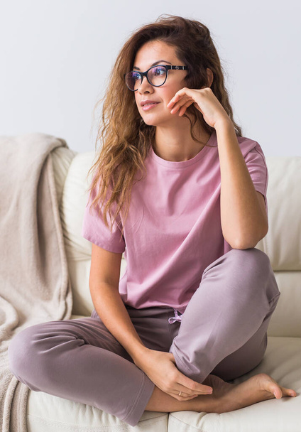 Young attractive woman dressed in beautiful colorful pajama posing as a model in her living room. Comfortable sleepwear, home relaxation and female fashion concept. - Φωτογραφία, εικόνα