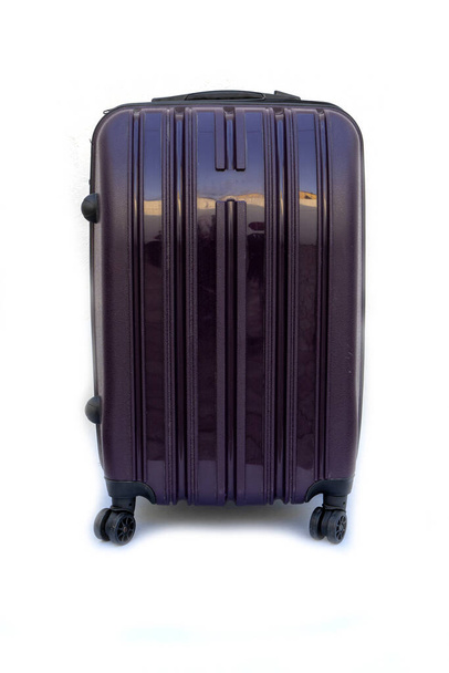 Black plastic travel suitcase on wheels on a white background. Concept of tourism and travel. - Foto, imagen