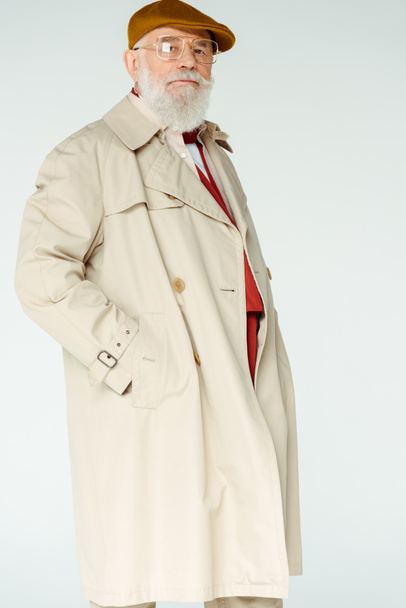 Stylish senior man in trench coat and eyeglasses looking at camera isolated on white  - Foto, Imagem