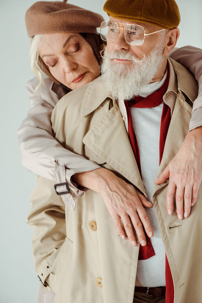 Stylish senior woman embracing handsome man isolated on grey - Photo, Image