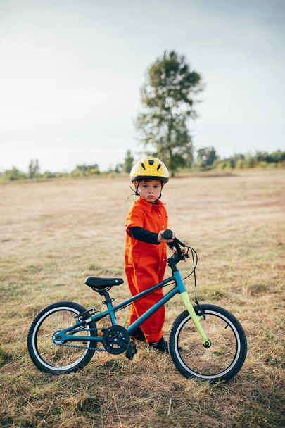 little boy in helmet riding bicycle outdoors  - Photo, image