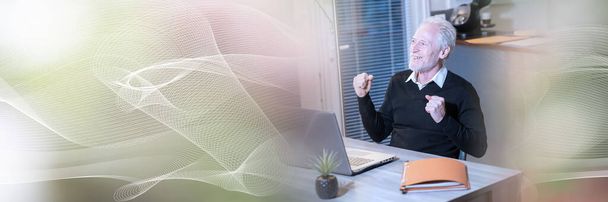 Lächelnder Geschäftsmann zeigt Erfolgsgeste vor seinem Laptop; Panorama-Banner - Foto, Bild
