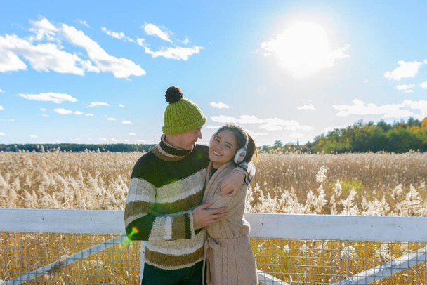若い多民族のカップルの肖像画一緒に秋のフィールドの風光明媚な景色に対する愛 - 写真・画像