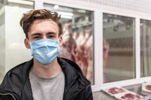 Hombre joven que usa máscara médica desechable comprando en el supermercado durante el brote de neumonía por coronavirus. Protección y prevención de medidas durante el tiempo de epidemia. Covid-19 persona
 - Foto, imagen