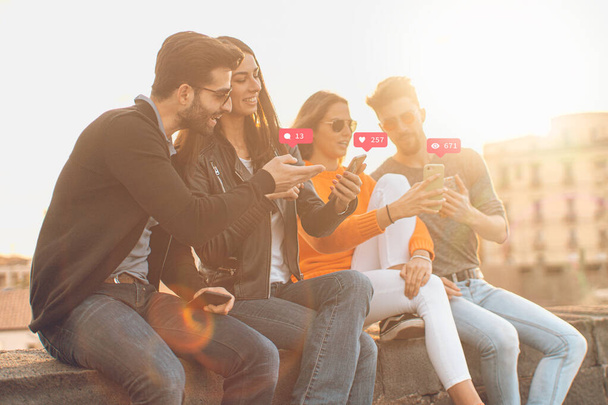 young people using smartphones outdoors, two couples  - Photo, Image