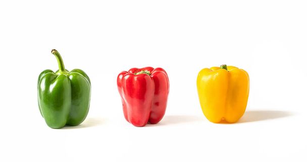 Vihreä, punainen ja keltainen pepperoni eristetty valkoisella pohjalla. Asetelma varjossa
 - Valokuva, kuva