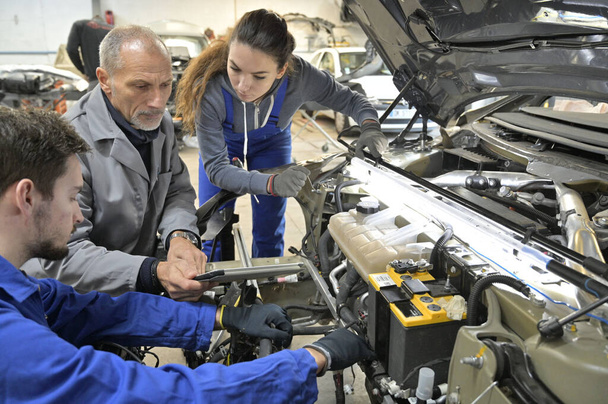 Instructor with trainees working on car engine  - Fotoğraf, Görsel