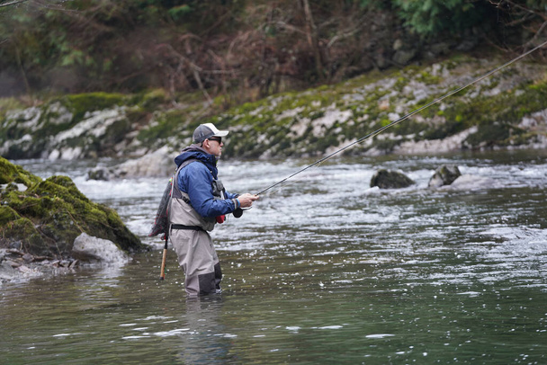 trout fly fisherman in river - Foto, afbeelding