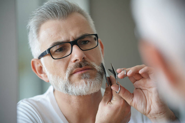 Portrait of man taking care of beard - Foto, afbeelding