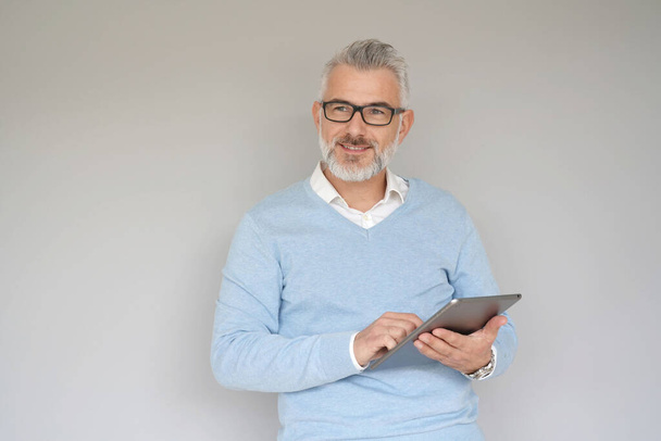 Middle-aged man using tablet, isolated on grey background - Foto, Imagem