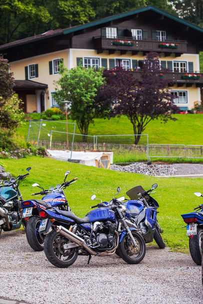 Lofer, Austria - June 1, 2018: The motorcycles is parked among the old wooden houses in Austria. - Fotoğraf, Görsel