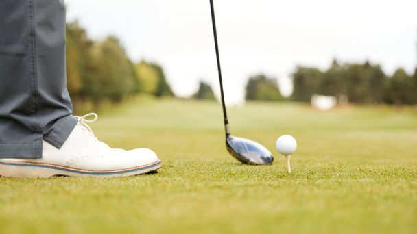 Close Up Of Mature Male Golfer Preparing To Hit Tee Shot Along Fairway With Driver - 写真・画像