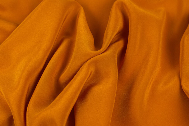 Golden silk or satin luxury fabric texture can use as abstract background. Top view. - 写真・画像