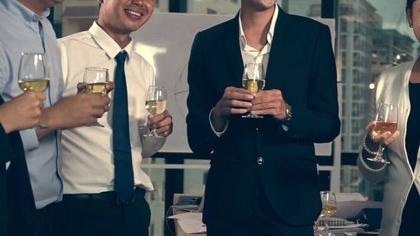Udane biznesmeni piją wino i szampana z członkami zespołu w sali balowej, aby uczcić biznesowy projekt wprowadzenia nowego produktu na rynek. Koncepcja sieci kontaktów biznesowych i międzyludzkich. - Zdjęcie, obraz