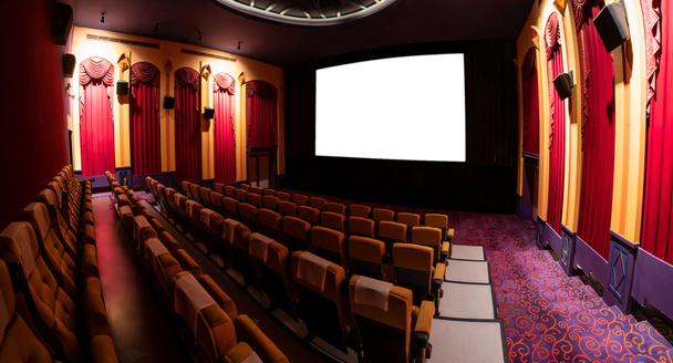 Kinoleinwand vor den Sitzreihen im Kinosaal mit einer weißen Leinwand, die vom Kinematographen projiziert wird. Das Kinosaal ist im klassischen Stil eingerichtet, um ein luxuriöses Kinogefühl zu erzeugen. - Foto, Bild