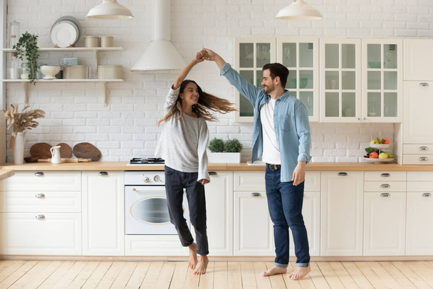 Happy loving couple having fun in kitchen, dancing together - Фото, зображення