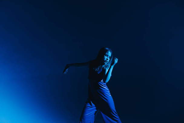 Junge stilvolle Mädchen tanzen im Studio auf farbigem Neon-Hintergrund. Klassischer Tänzer. - Foto, Bild