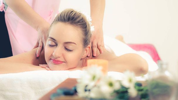 Rahat bir kadın profesyonel masaj terapistiyle lüks kaplıcalarda masaj yaptırıyor. Sağlık, şifa ve rahatlama konsepti. - Fotoğraf, Görsel