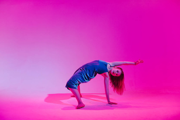 Joven chica elegante bailando en el estudio sobre un fondo de neón de color. Diseño de póster de música dj
. - Foto, Imagen