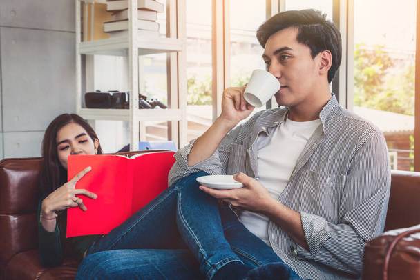Glückliches asiatisches Paar trinkt zu Hause Kaffee. Liebesbeziehung und Lebensstil-Konzept. - Foto, Bild