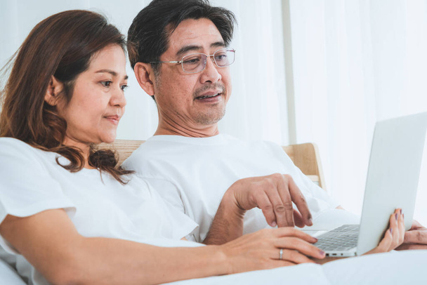 幸せなアジアの高齢者のカップルは家で楽しい時間を過ごしています。高齢者の退職と健康的な高齢者の概念. - 写真・画像