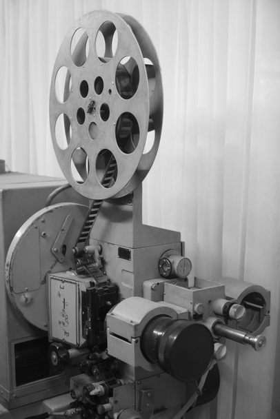 Vintageprojektori on päällä. Linssistä poistuva valo. Harvinainen teollinen elokuva 35 mm elokuva tulostin yksityiskohtaisesti vintage mustavalkoinen, analoginen optinen prosessi rgb valaisimet ja rullat jälkituotanto tehdas
 - Valokuva, kuva