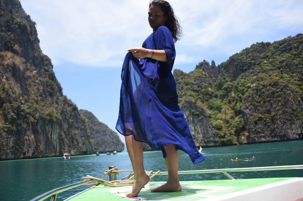 Gyönyörű lány a hajó orrán a sziget zöld sziklái körül Phi Phi - Fotó, kép