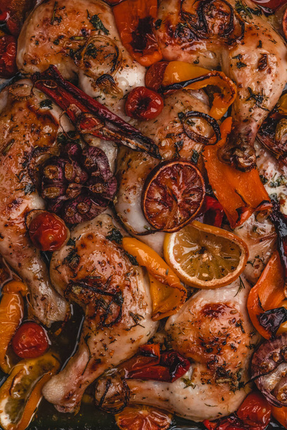 Roasted chicken legs with vegetables and oranges on metal tray, top view - Foto, Bild