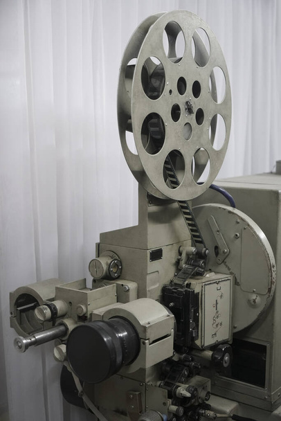 zabytkowy projektor włączony. Światło wychodzące z obiektywu. Rzadkie kino przemysłowe 35 mm film szczegółowo vintage czarno-biały, analogowy proces optyczny z lampami rgb i kołowrotki w fabryce postprodukcji - Zdjęcie, obraz