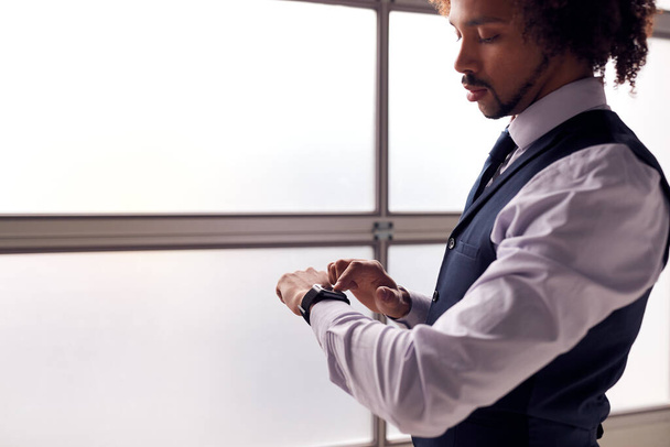 Businessman Wearing Suit Looking At Smart Watch In Office - Foto, immagini