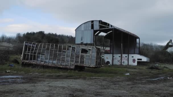 Um transporte de cavalos danificado e abrigo abandonado num campo com relva e árvores na Irlanda do Norte. - tiro de rastreamento
 - Filmagem, Vídeo
