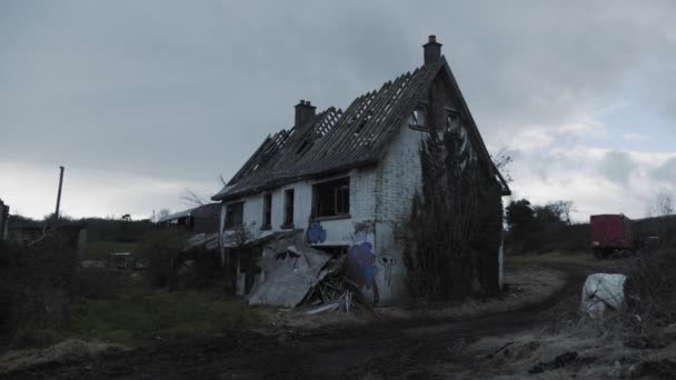 Kézzel fogható közelítés az elhagyott házhoz graffitivel egy felhős égbolton Észak-Írországban. - Széles látókörű. - Felvétel, videó