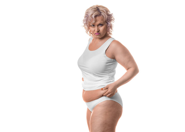 Retrato de una mujer de mediana edad infeliz con su figura. Celulitis y obesidad
. - Foto, Imagen