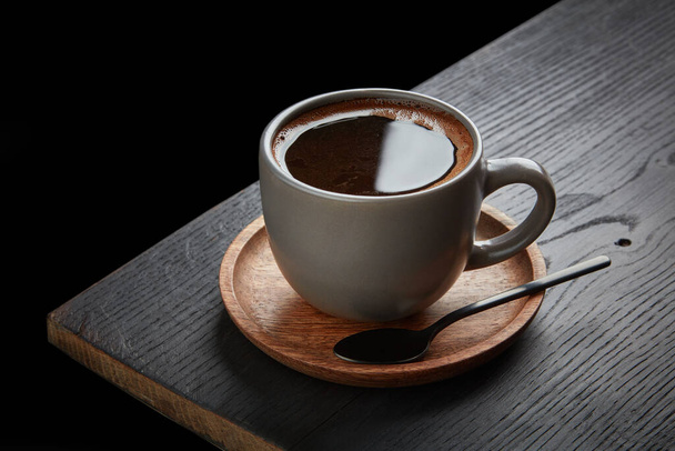 kopje zwarte koffie op houten tafel - Foto, afbeelding